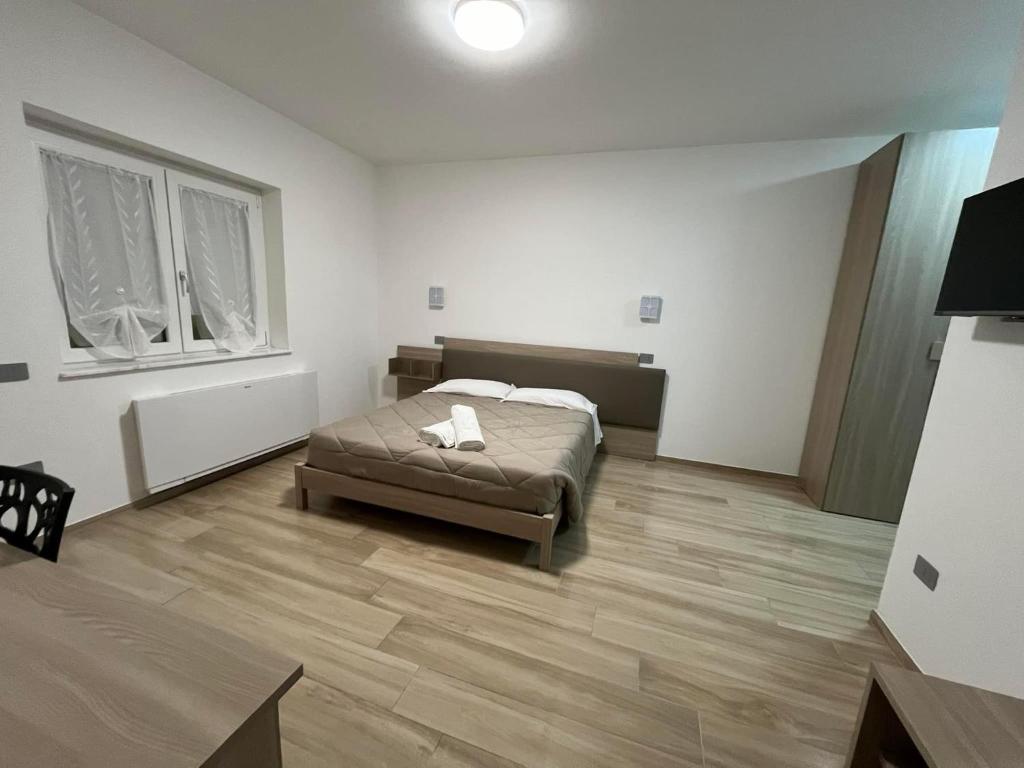 sypialnia z łóżkiem i drewnianą podłogą w obiekcie B&B La Terrazza w mieście Cotronei