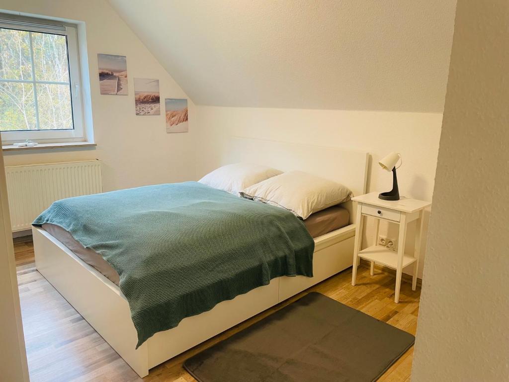 um quarto com uma cama e uma mesa com um candeeiro em Ferienwohnung Edental em Burgdorf