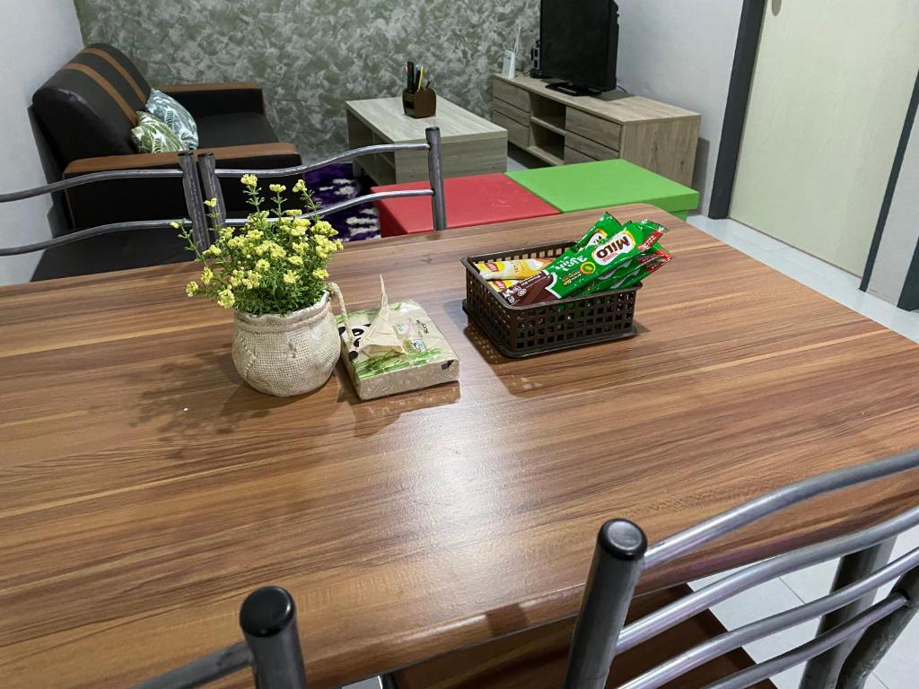 a wooden table with a vase of flowers on it at The Time in Kota Samarahan