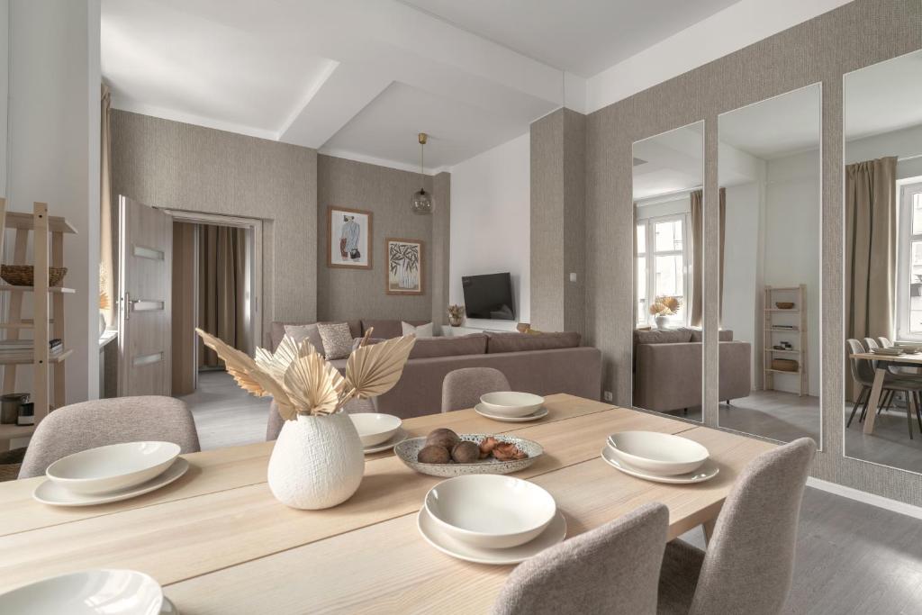 a living room with a wooden table with chairs and a couch at HARBOR APARTMENTS - Damrota in Katowice