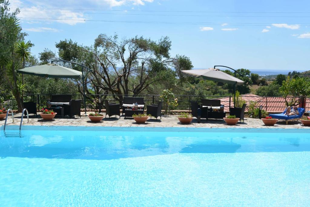uma piscina com mesas, cadeiras e guarda-sóis em Casa Vacanze Villa Francy em Marina di Camerota