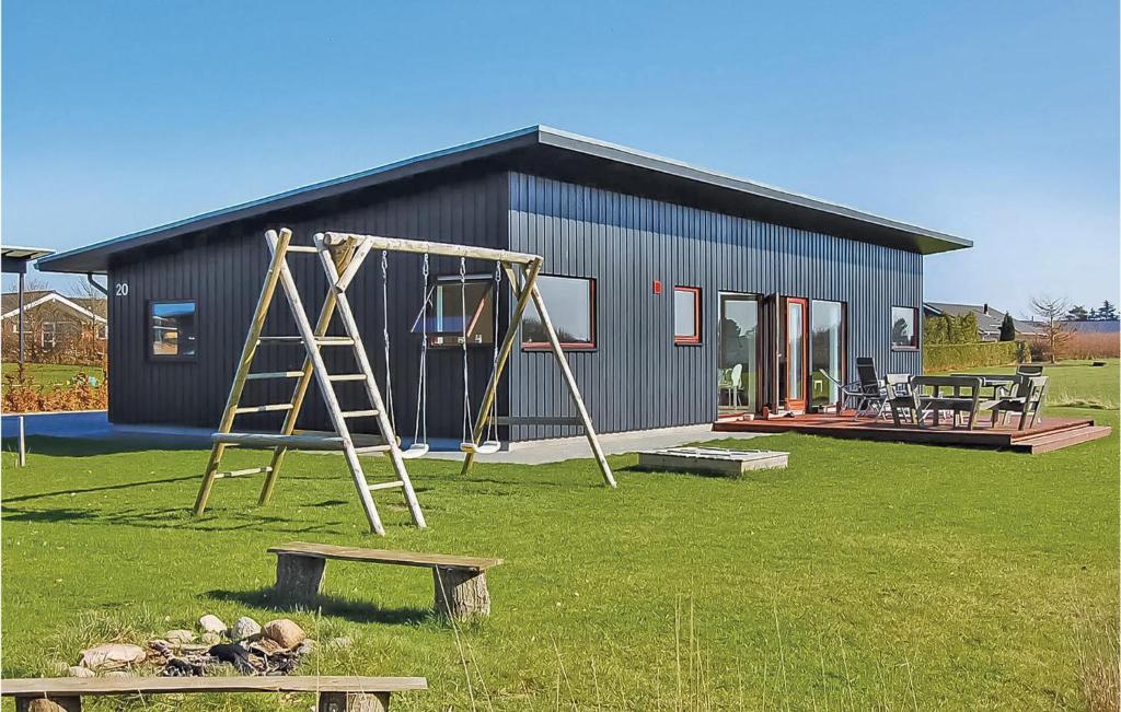 una pequeña casa con un parque infantil delante de ella en Beautiful Home In Haderslev With Wifi, en Årøsund