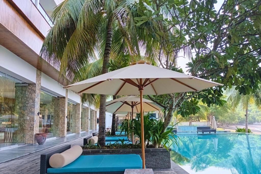 an umbrella sitting next to a swimming pool at Brave The Ocean 1 BR Beach View NE31 in Teluknarat