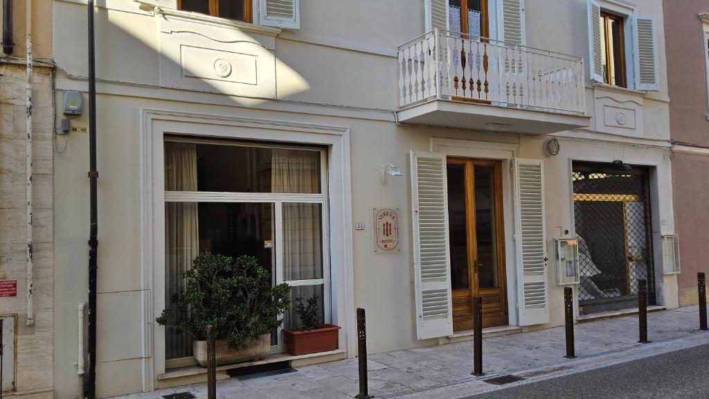 a white building with a balcony on a street at Verena Dependance Savoia & Campana in Montecatini Terme