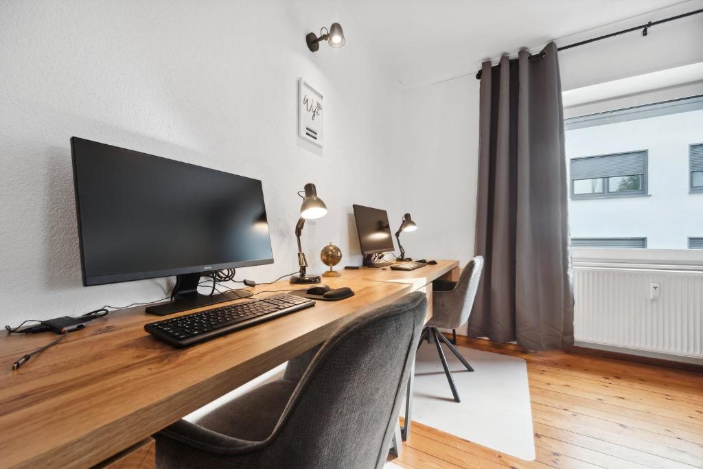 escritorio con monitor de ordenador y teclado en ANDRISS - Serviced Apartments I Workstations I WIFI en Kaiserslautern