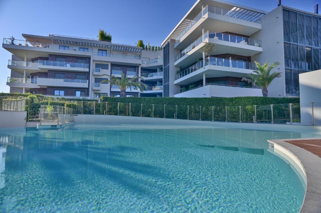 une piscine devant un immeuble dans l'établissement First Cap - Luxury 1BR with terrace in the most prestigious development of the French Riviera, à Antibes