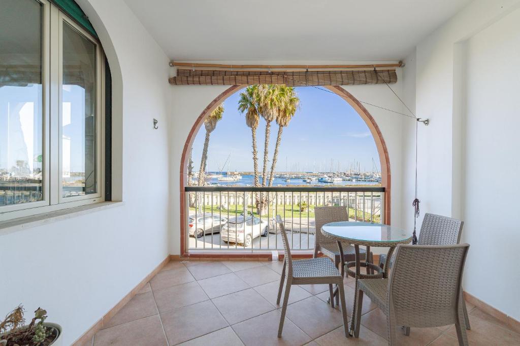 a dining room with a table and chairs and a window at Marzamemi Porto in Marzamemi