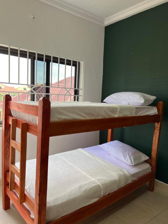 two bunk beds in a room with a window at Serene Hostel in Aboman