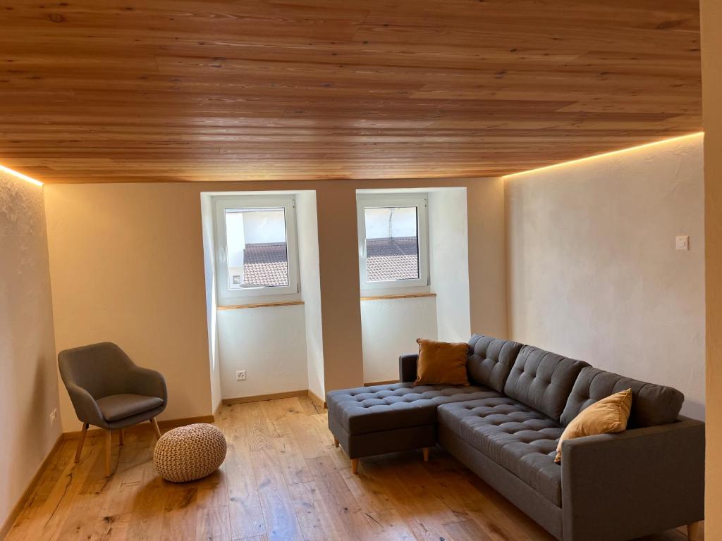 un soggiorno con divano e 2 finestre di Appartement Rosa au coeur des 4 Vallées a Conthey