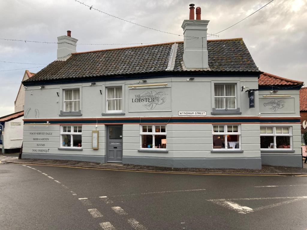 un bâtiment blanc sur le côté d'une rue dans l'établissement The Lobster, à Sheringham