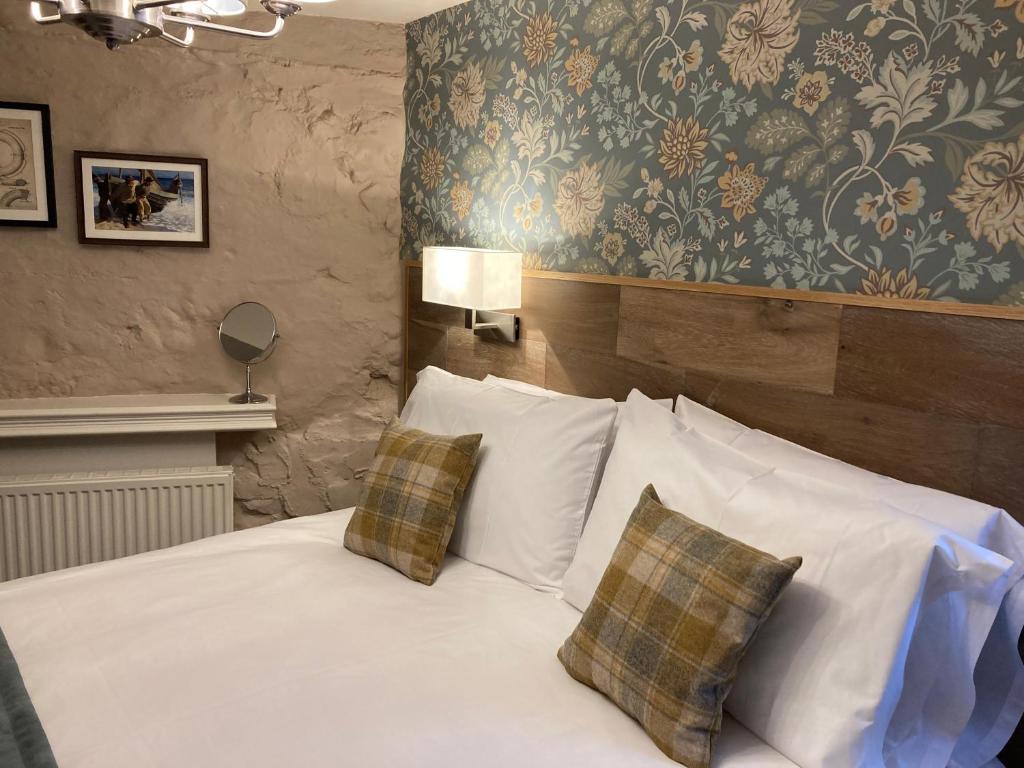 a bedroom with a white bed with two pillows at The Lobster in Sheringham