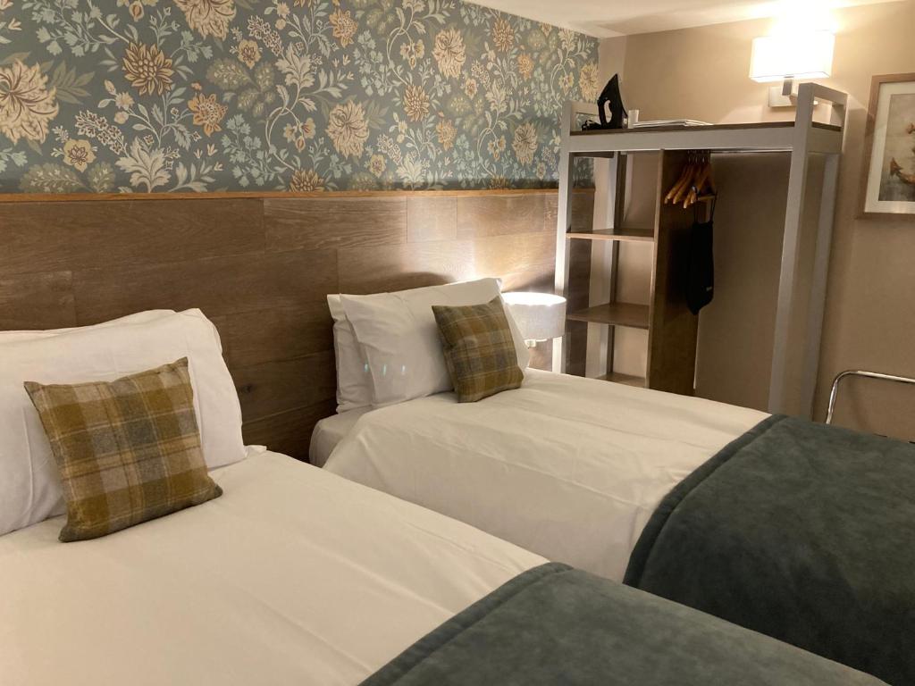 a hotel room with two beds and a wall at The Lobster in Sheringham