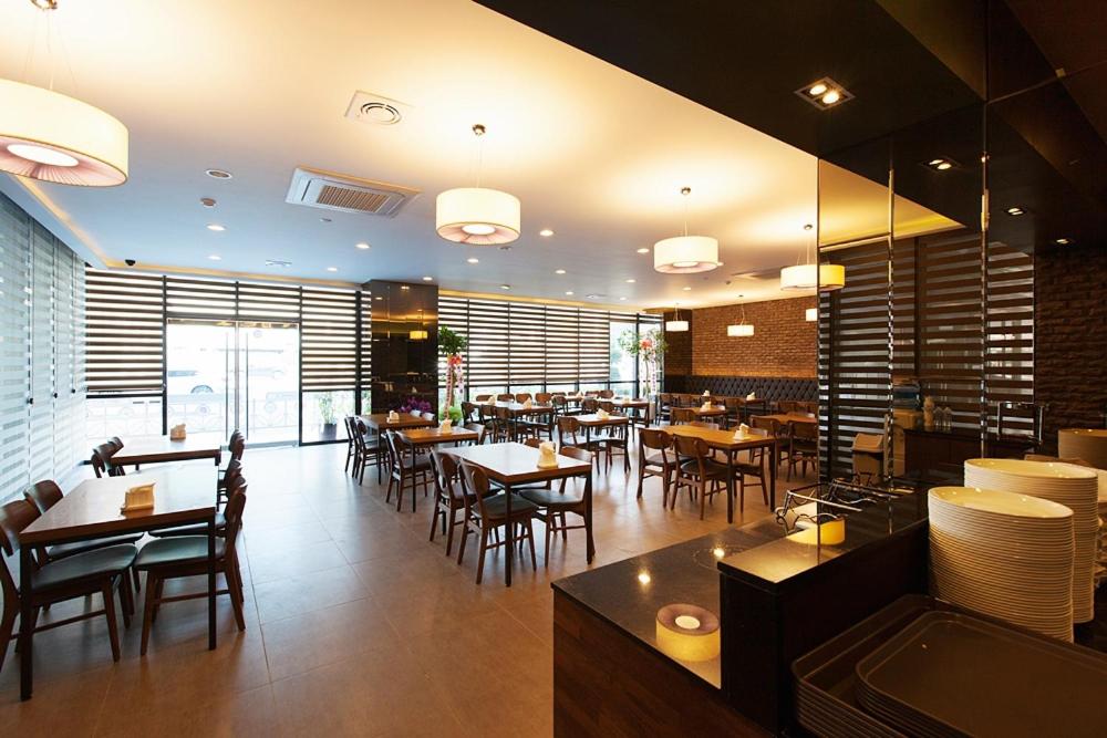 a dining room with tables and chairs and a restaurant at Wolmido Premiers Hotel in Incheon