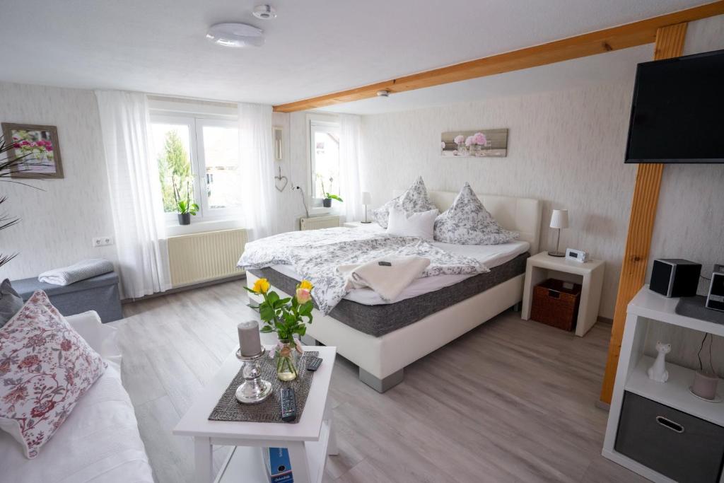 a bedroom with a bed and a living room at Ferienwohnungen KATI in Scheidegg