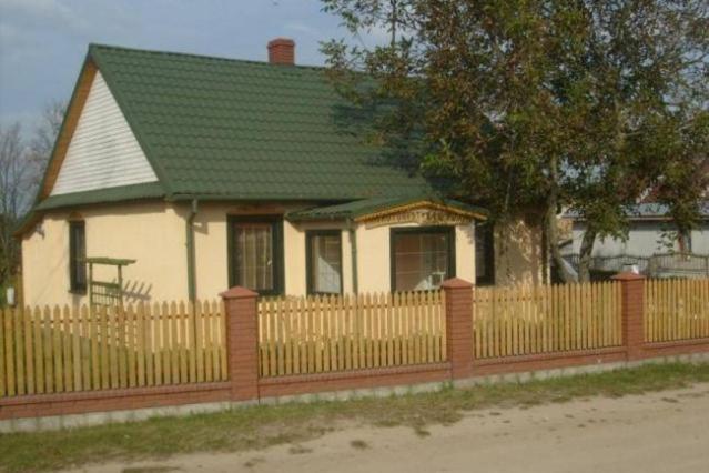 una casa con una valla de madera delante de ella en Agroturystyka u Kwiatka, en Janów Podlaski
