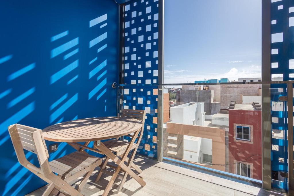 Una mesa y sillas en un balcón con vista. en Lightbooking Apartamento con terraza en playa de Arinaga, en Agüimes