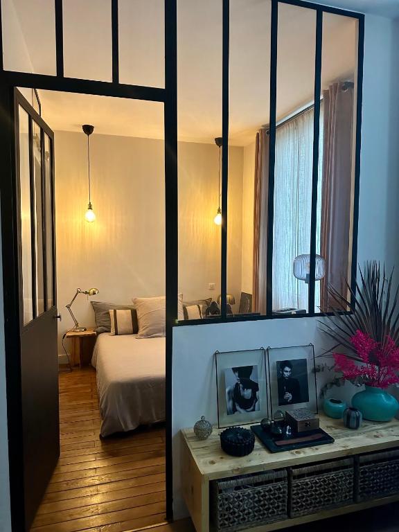 a room with a bedroom with a bed and a mirror at Appartement Cosy Paris Montmartre in Paris
