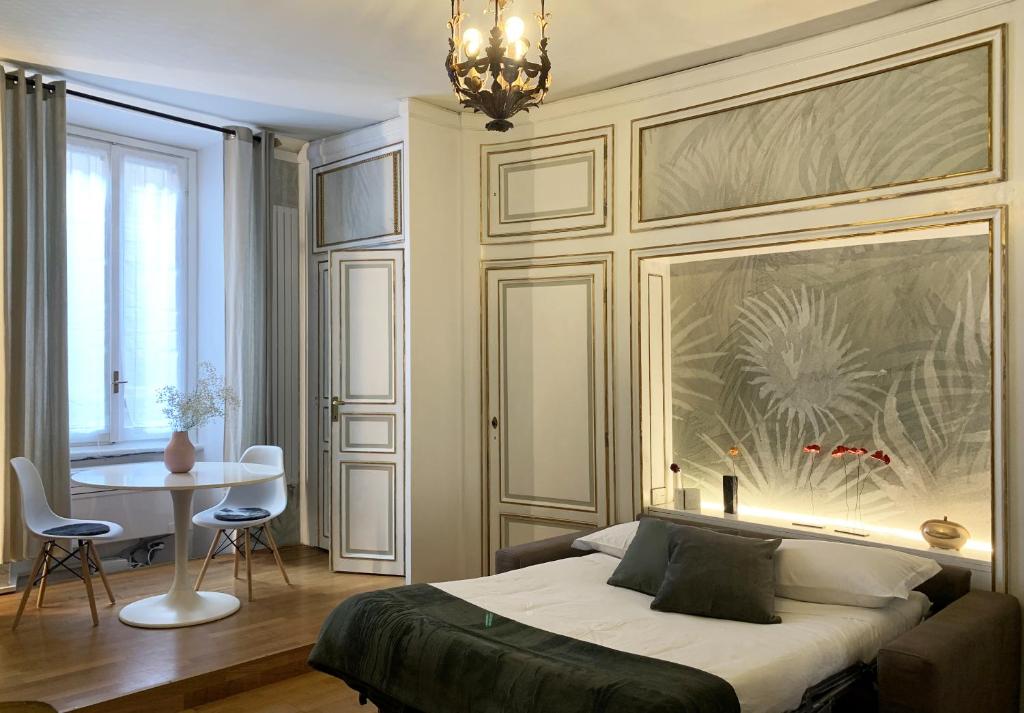 1 dormitorio con cama, mesa y lámpara de araña en HomeMi Sant'Ambrogio Apartment en Milán