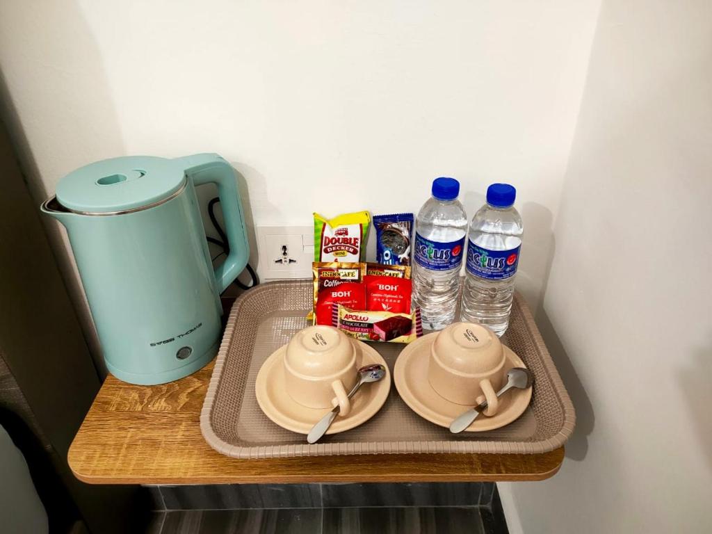 タイピンにあるKIWI INNのテーブルの上に皿とボトル入り飲料水を用意したトレイ