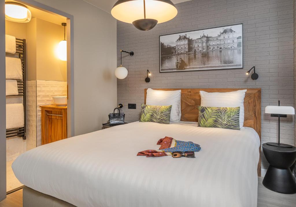 sypialnia z dużym białym łóżkiem z 2 poduszkami w obiekcie Appart'hôtel East Paris Suite w Paryżu