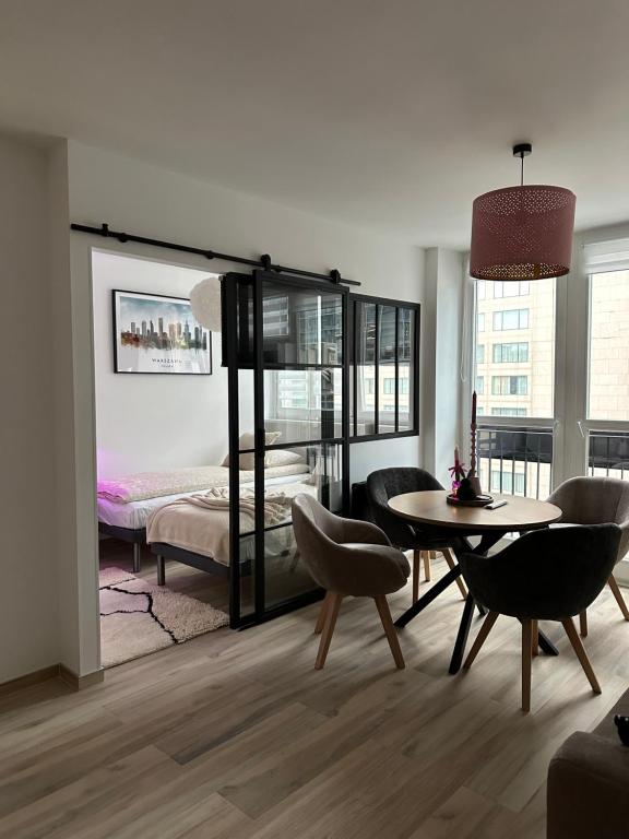 華沙的住宿－Apartament Centrum Warszawy Pereca，客厅配有床和桌椅