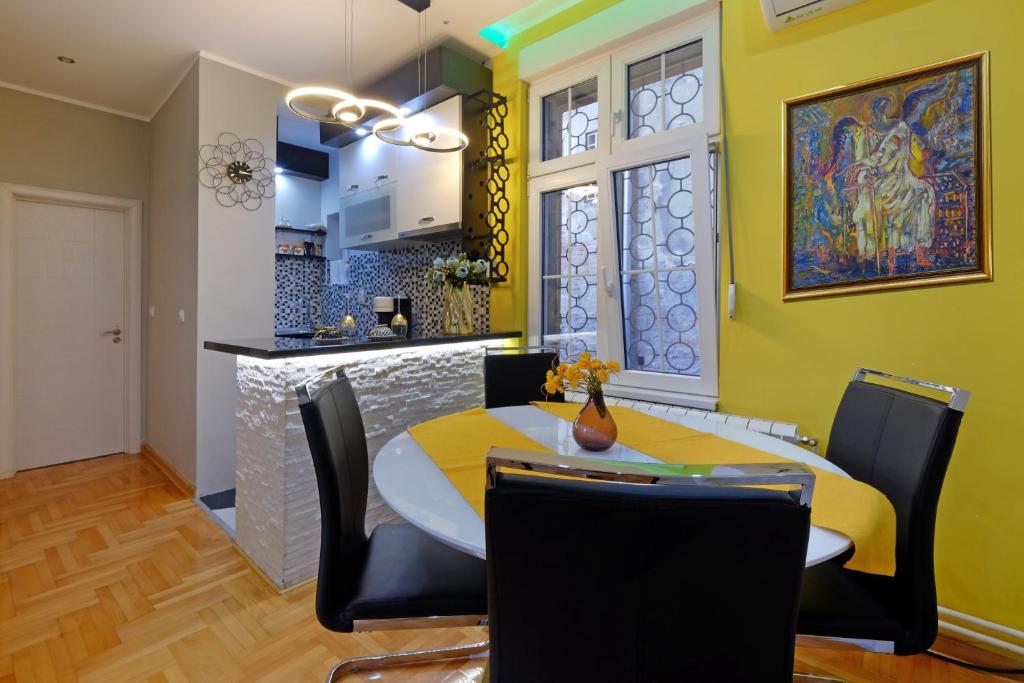 eine Küche und ein Esszimmer mit Tisch und Stühlen in der Unterkunft APARTMAN KRUNA in Belgrad