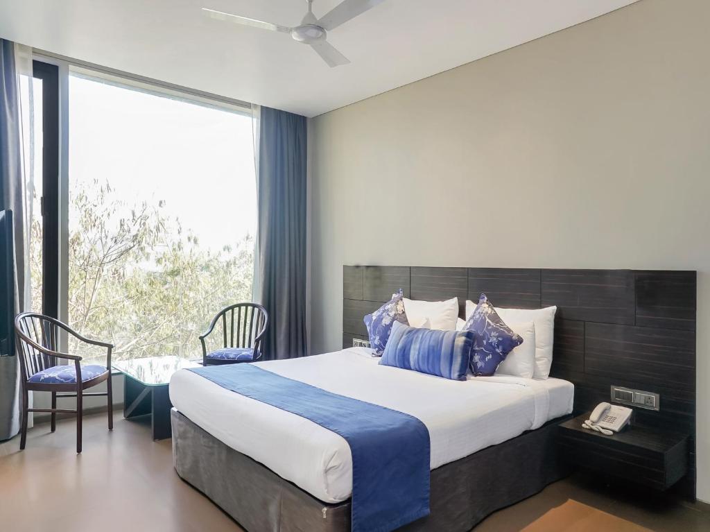 Un dormitorio con una cama grande y una ventana en Treebo Trend Niraali Executive en Pune