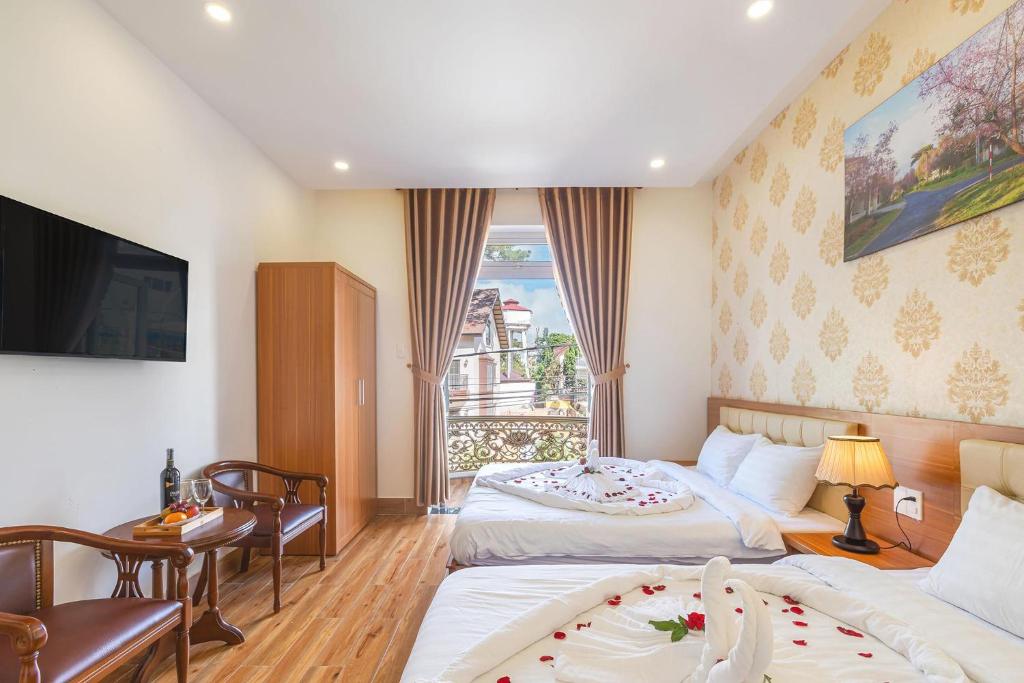 ダラットにあるVilla Hoa Ly Đà Lạtのベッド2台とテレビがあるホテルの部屋