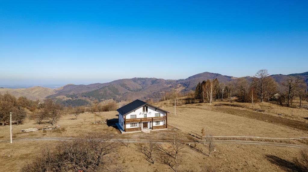 a house on a hill with mountains in the background at Casa Davana in Cluj-Napoca