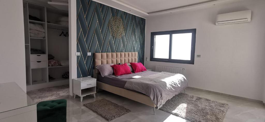Villa B&B في سوسة: غرفة نوم مع سرير مع وسائد وردية عليه