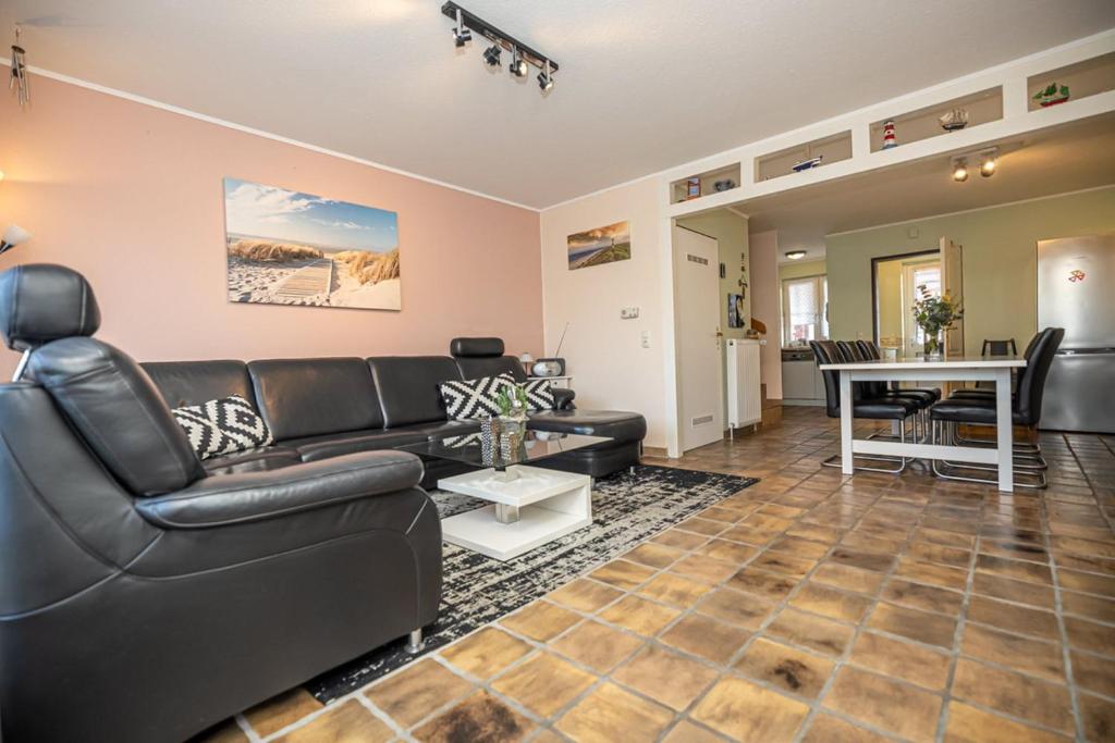 un salon avec un canapé et une table dans l'établissement Ferienhaus Seeschwalbe, FeWo Vermittlung Nordsee, à Dangast