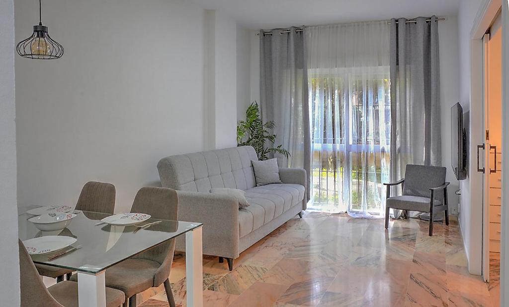 sala de estar con sofá y mesa en Precioso piso residencial en Sevilla