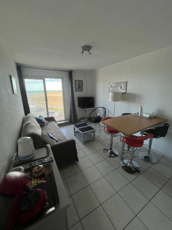 un salon avec un canapé et une table dans l'établissement La mer pour décor de fond, à Saint Pierre La Mer