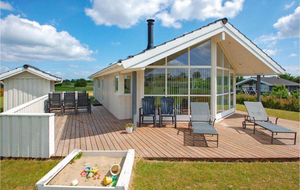 a house with a deck with chairs and a table at Amazing Home In Haderslev With 4 Bedrooms And Wifi in Flovt