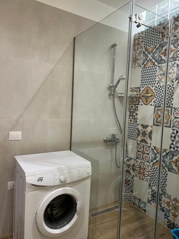 een wasmachine in een badkamer met een douche bij SKetch Apartments in Durrës