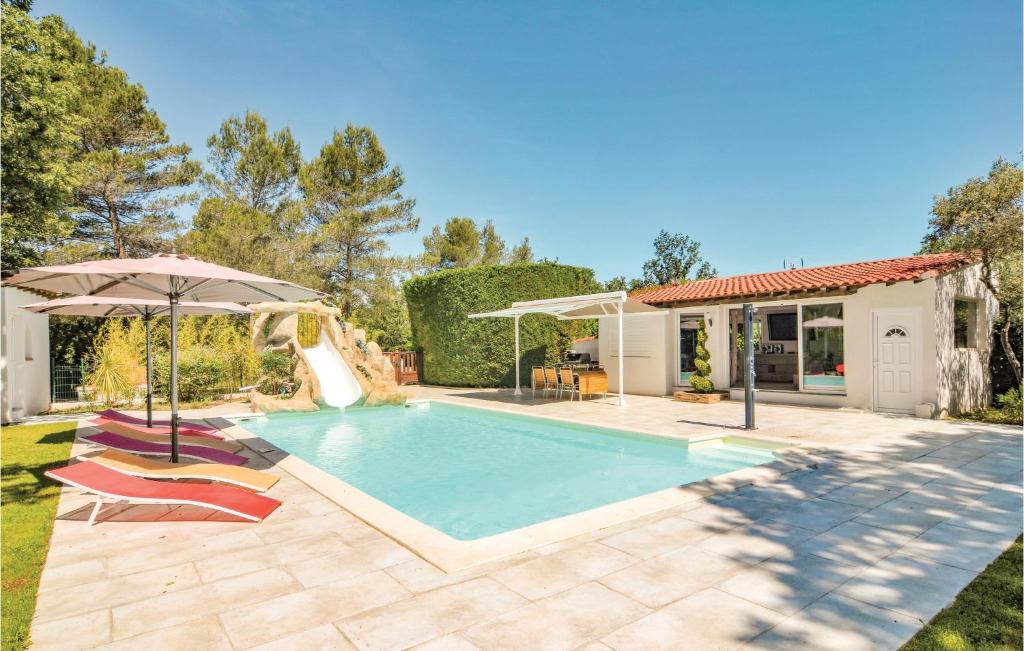 a swimming pool with two chairs and an umbrella at Pet Friendly Home In Trets With Heated Swimming Pool in Trets