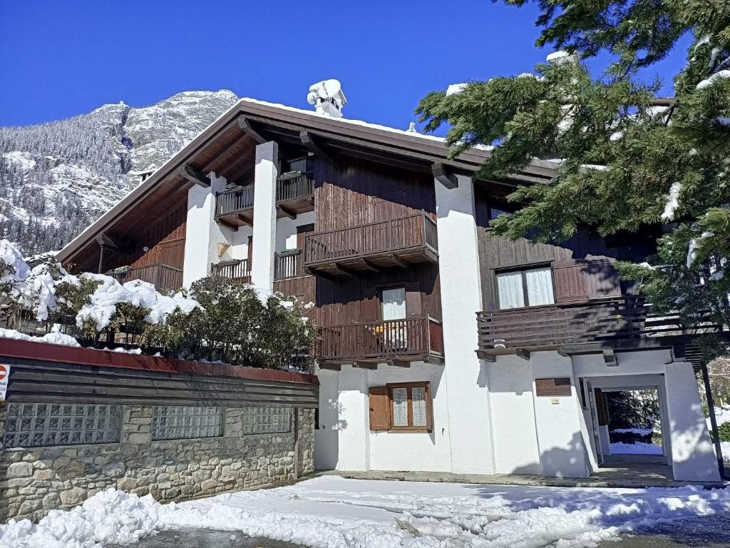 a building with wooden balconies on a mountain at Apartment "La maison des Guides" in Courmayeur