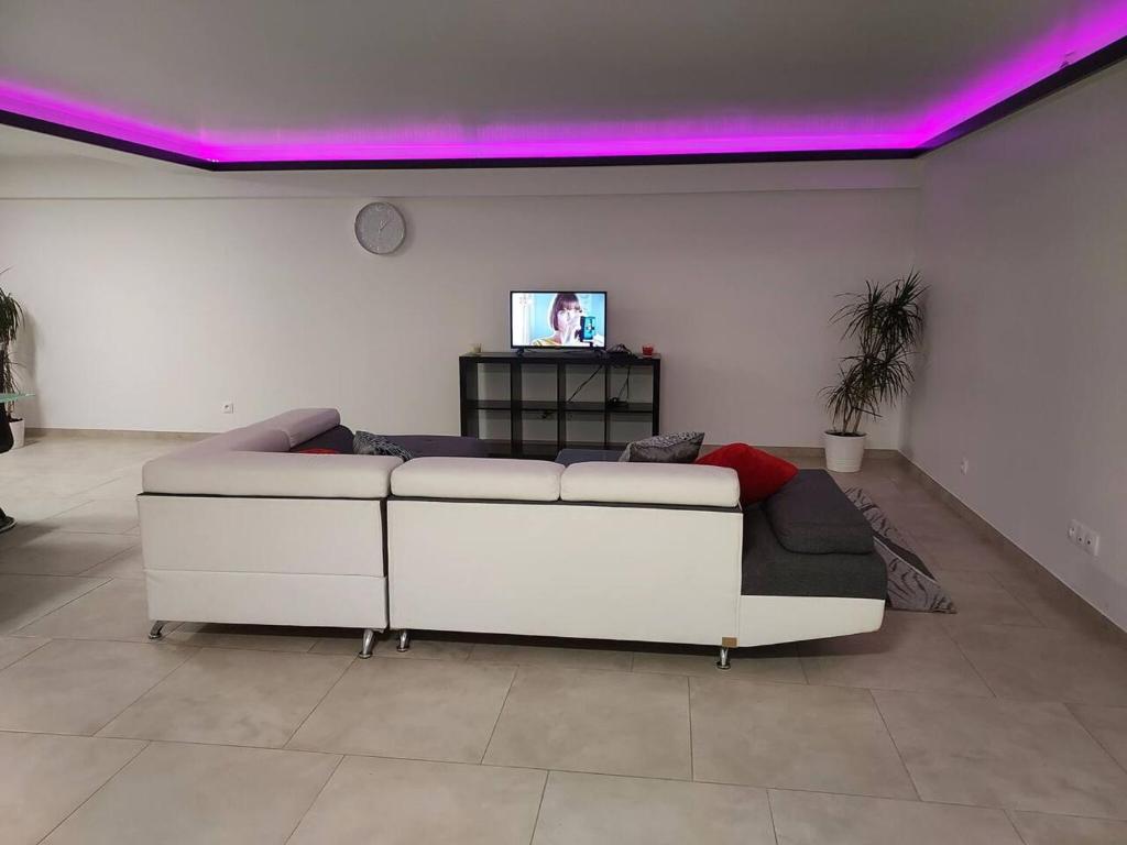 a white couch in a room with purple lights at Appartement d'une chambre avec terrasse et wifi a Saintry sur Seine in Saintry-sur-Seine