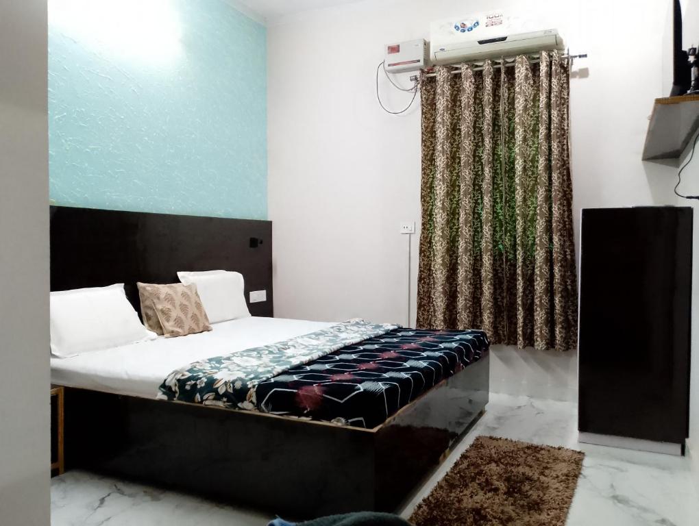 a bedroom with a bed and a television in it at The blessings home stay in Agra