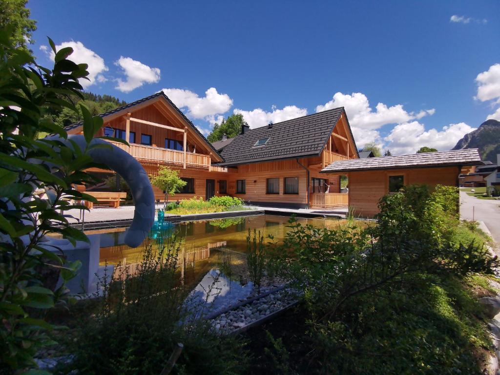 una casa de madera con un estanque delante de ella en Chalet Tauplitz en Bad Mitterndorf