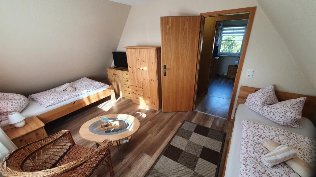 a small room with two beds and a table at Pension am Silberberg in Gartz an der Oder