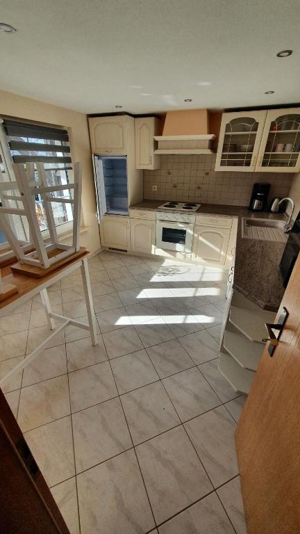 a kitchen with white cabinets and a tile floor at Pension am Silberberg in Gartz an der Oder
