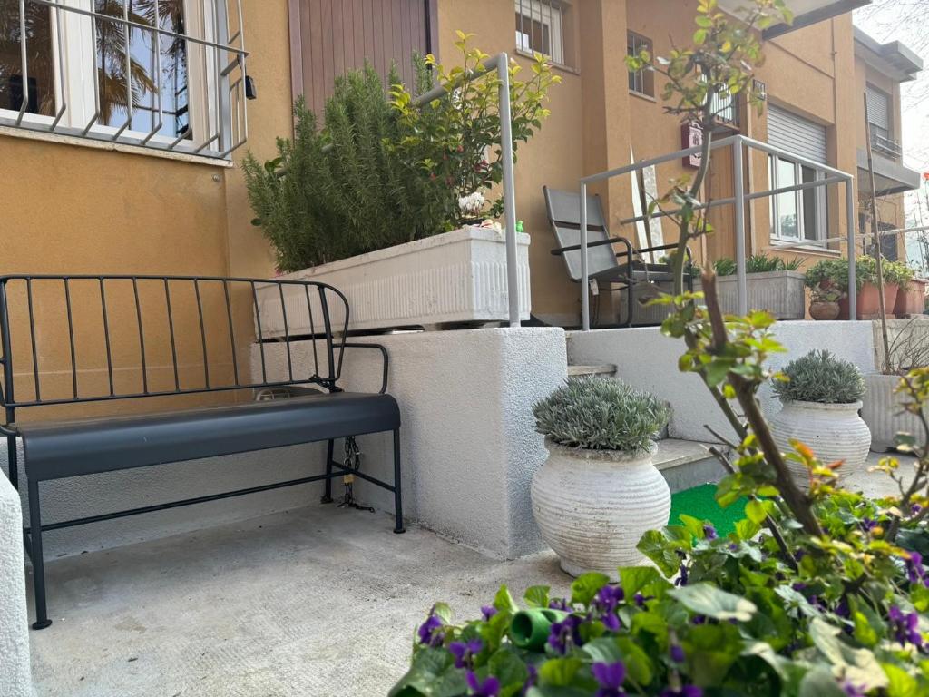 un banco sentado en un patio con algunas plantas en Villetta Forlanini Milano, en Milán