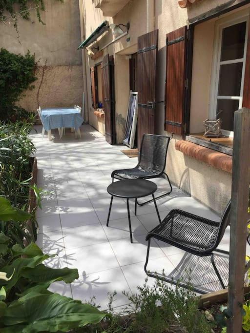 deux chaises et une table sur une terrasse dans l'établissement Coeur de Collioure - Parking - Rez de jardin, à Collioure