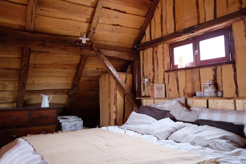 ein Schlafzimmer mit einem Bett in einem Holzzimmer in der Unterkunft Wooden love nest in Vransko