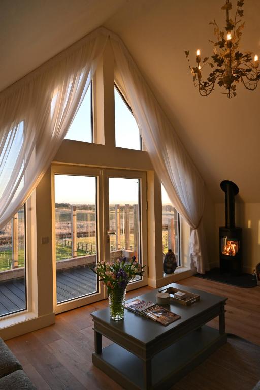 a living room with a large window and a table at Capercaillie Cottage - Luxury converted steading in Perth