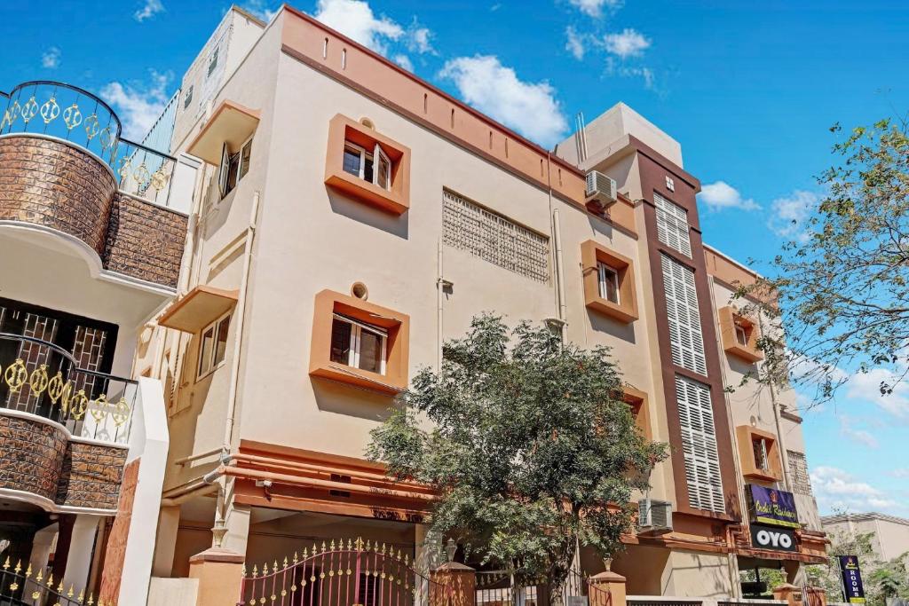 a building with a tree in front of it at Hotel Orchid Residency Medavakkam in Chennai