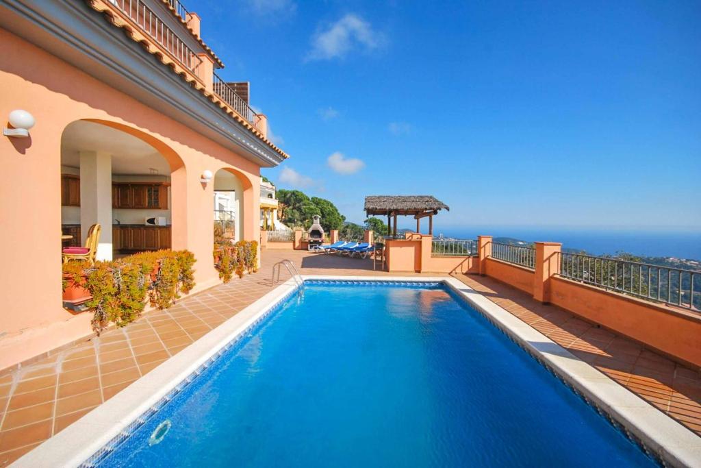 - une piscine en face d'une maison donnant sur l'océan dans l'établissement Villa Denise, à Lloret de Mar
