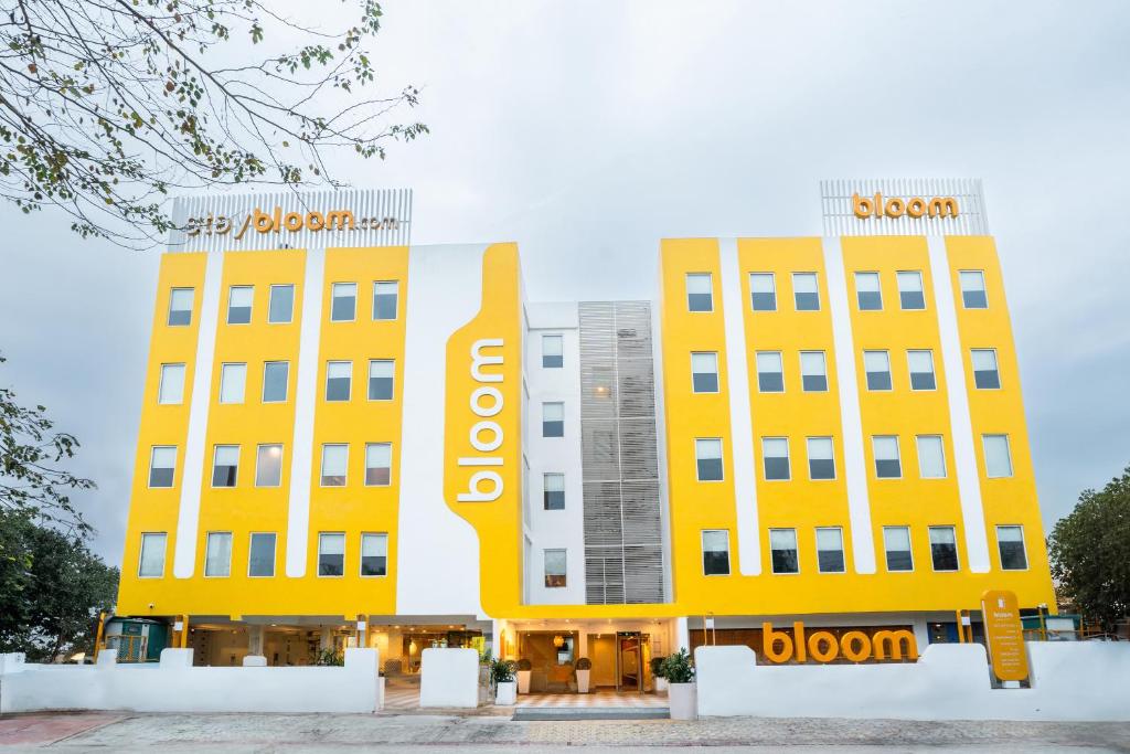 twee gele gebouwen met een sloan bord erop bij Bloom Hotel - Medicity Gurugram, Near Medanta Hospital in Gurgaon