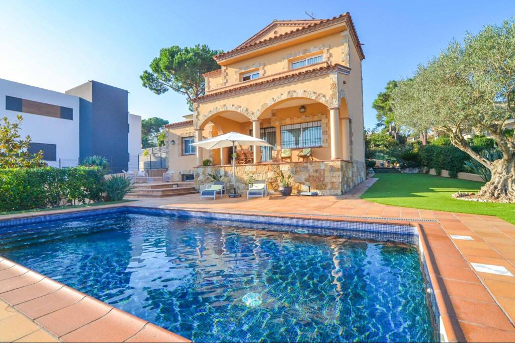 een huis met een zwembad voor een huis bij Villa Bouvardia in Lloret de Mar